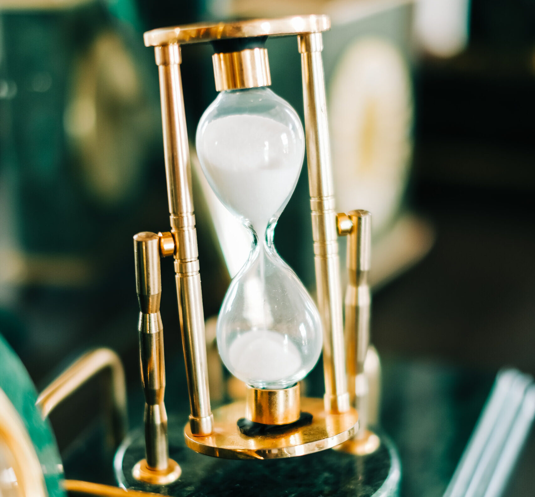 Vintage golden hourglass on the table, closeup.